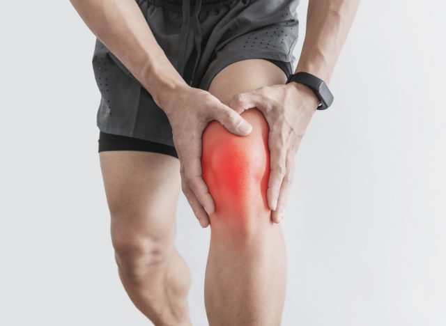 closeup man dealing with knee pain, arthritis