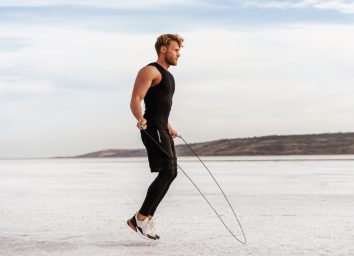 fit man demonstrating jumping rope, an exercise to shrink a flabby stomach