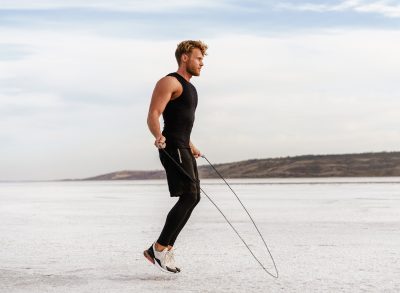 fit man demonstrating jumping rope, an exercise to shrink a flabby stomach
