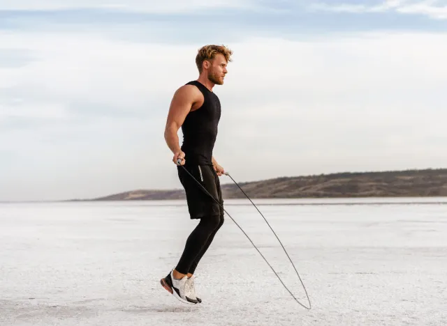 fit man weighted jump roping outside at beach