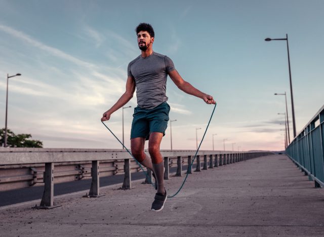 fit man demonstrating weighted jump roping outside