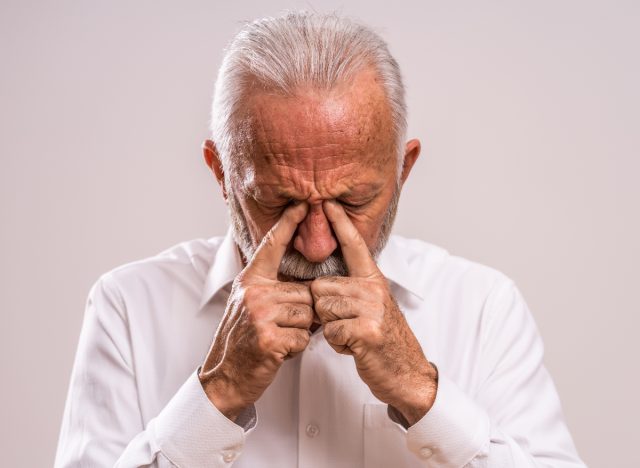 man massaging his face dealing with sinus pressure and seasonal allergies