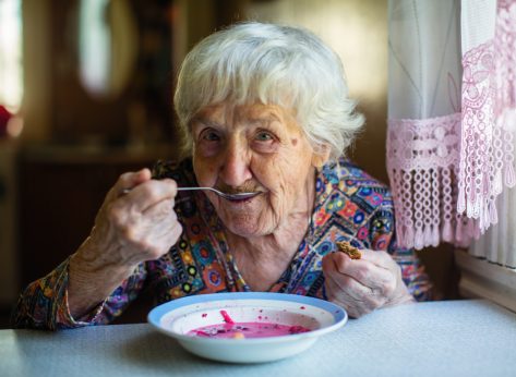 old woman eating soup