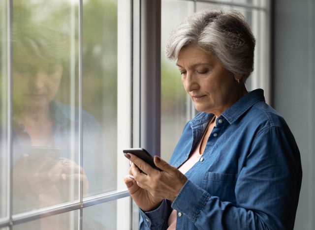 vyresnio amžiaus moteris rašo žinutes namuose, naudodama programą, kad patikrintų, ar nėra Alzheimerio ligos