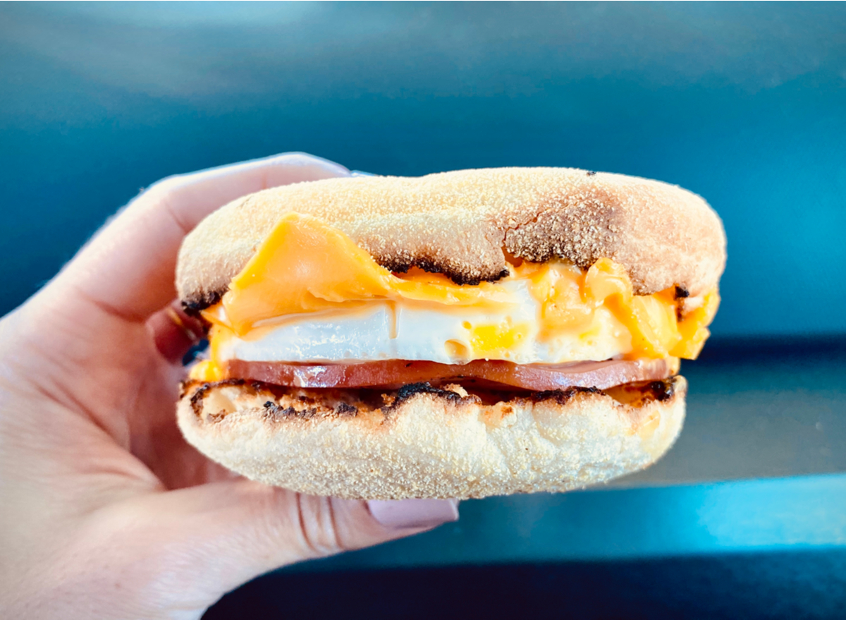 person holding breakfast sandwich