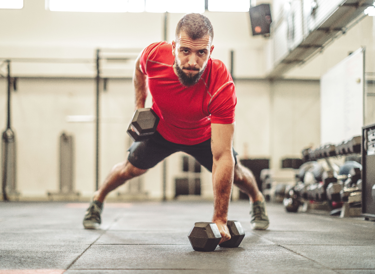 man demonstrating dumbbell renegade row to shrink abdominal fat