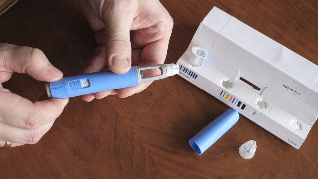 Man preparing Semaglutide Ozempic injection control blood sugar levels.