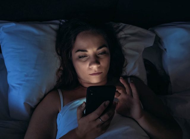 žena používá telefon v posteli, vedlejší účinky nespavosti