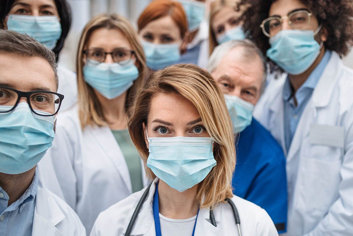 Group,Of,Doctors,With,Face,Masks,Looking,At,Camera,,Corona, warning