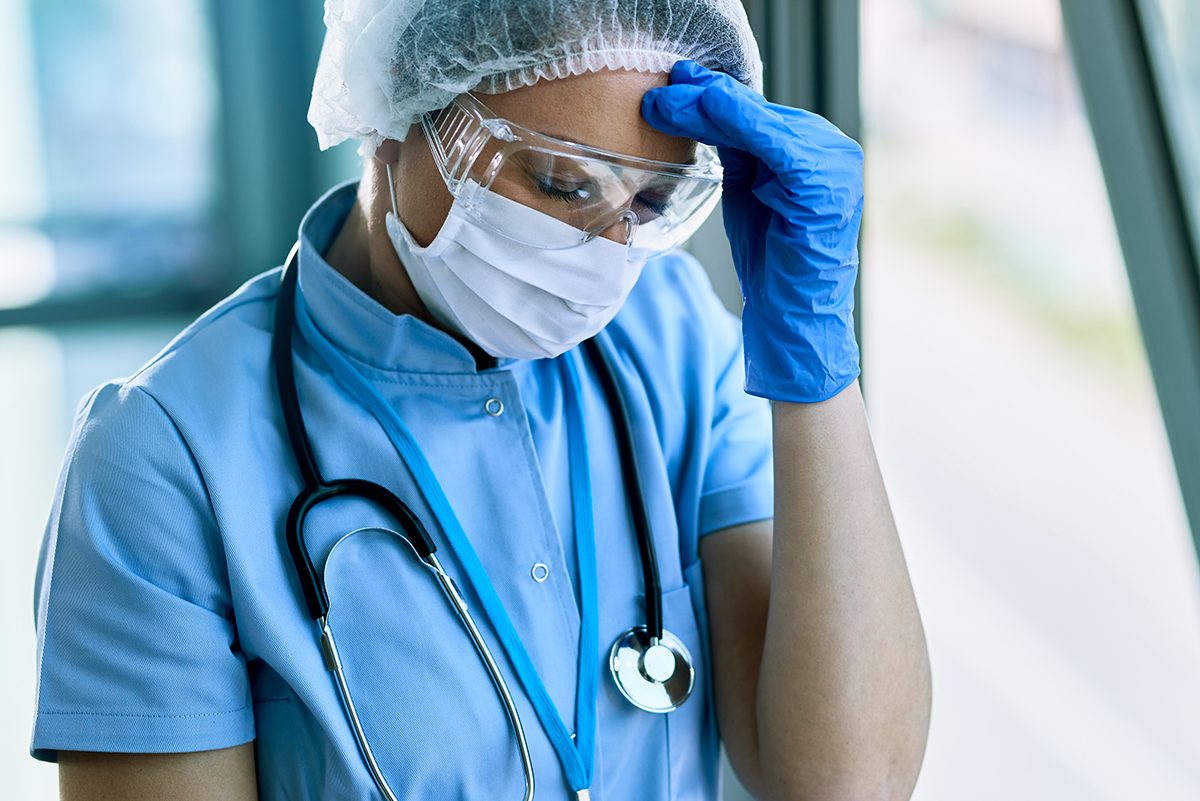 Exhausted,Female,Doctor,Having,Headache,While,Working,At,Clinic,During