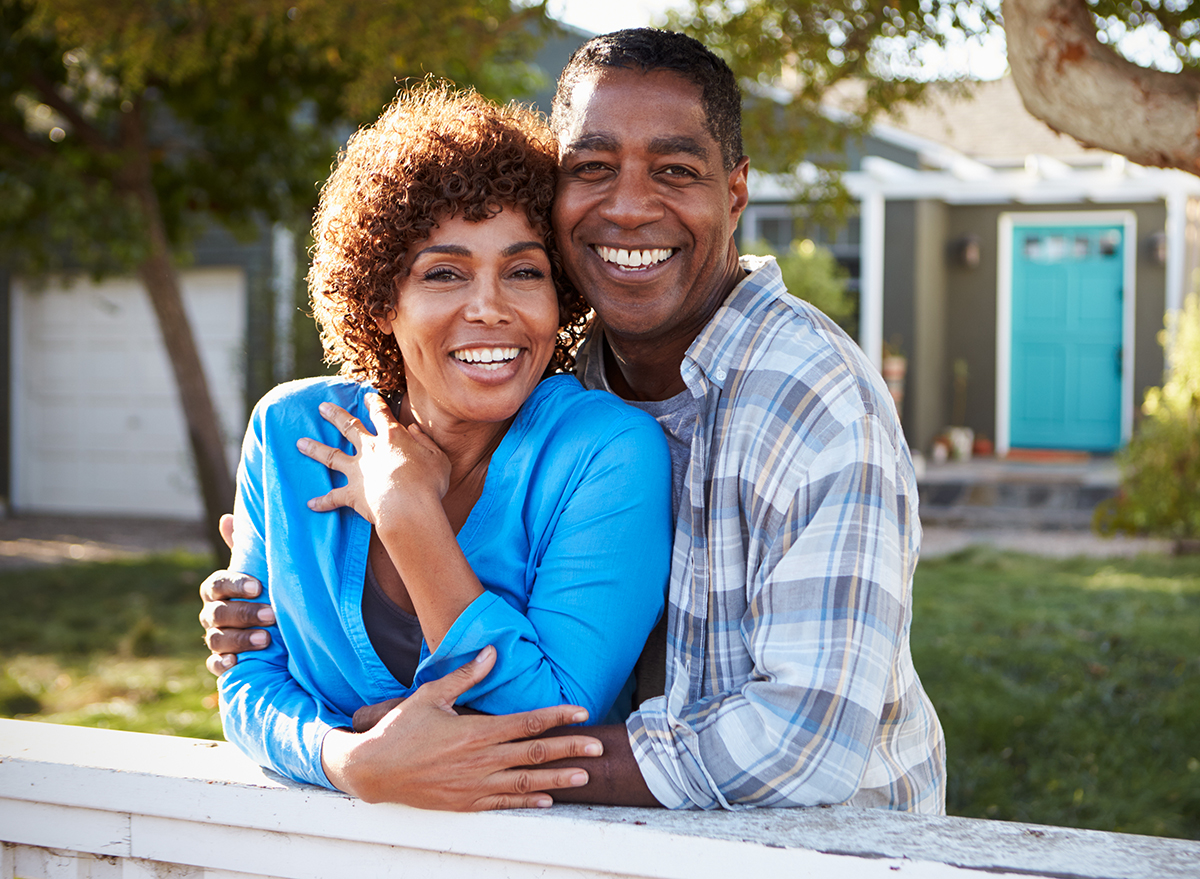 Portrait,Of,Mature,Couple,Looking,Over,Back,Yard,Fence