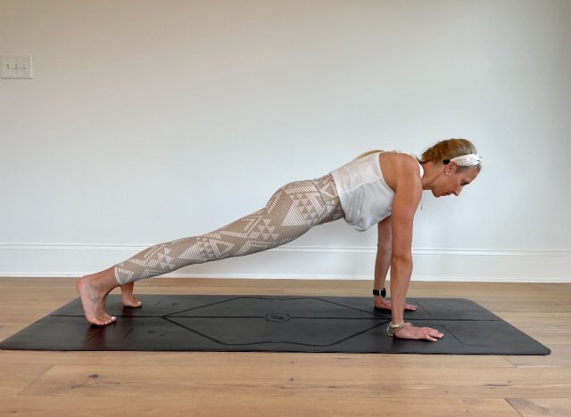 trainer demonstrating straight arm plank on mat