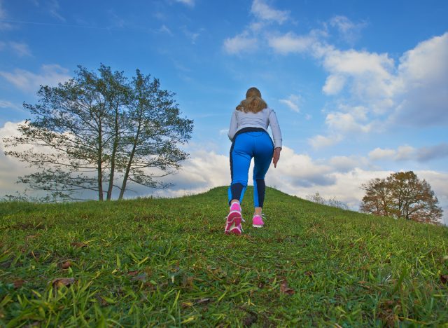 Göbek yağını daha hızlı küçültmek için yokuş yukarı yürüyüş egzersizi yapan kadın