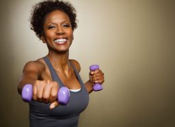woman in her 40s performing body-shaping workout with dumbbells