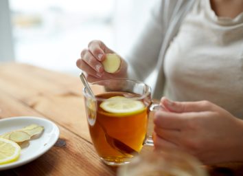 woman adding ginger to tea