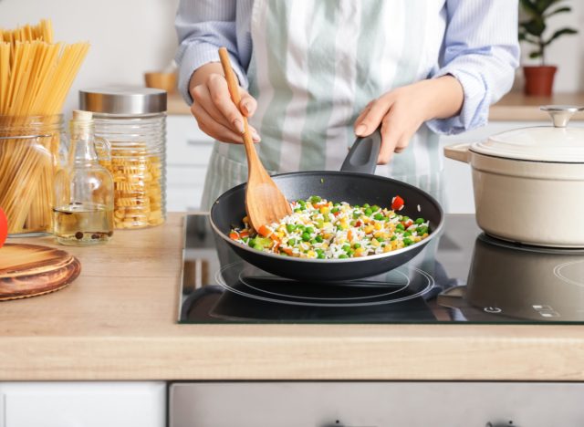 woman cooking rice and vegetables