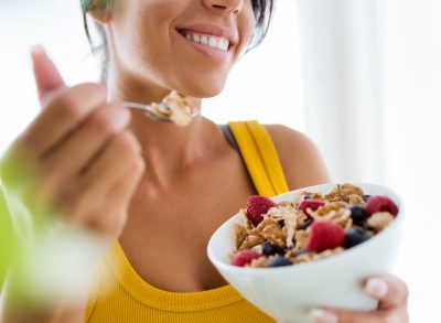 woman eating cereal with berries