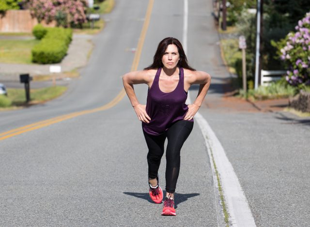 woman doing hilly outdoor walking workout to shrink belly fat faster