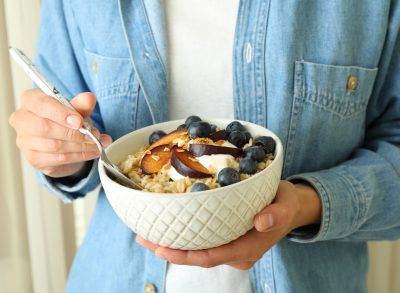 woman holding oatmeal with fruit