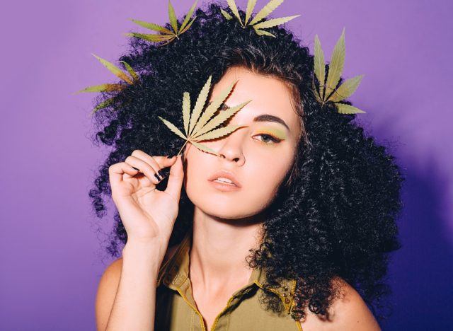 Portrait of a woman with cannabis leaf near her face