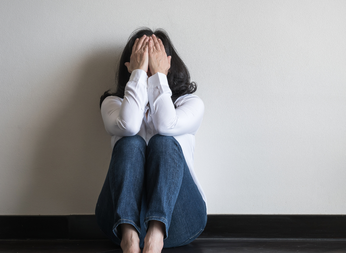 woman sitting on floor in home dealing with panic attack