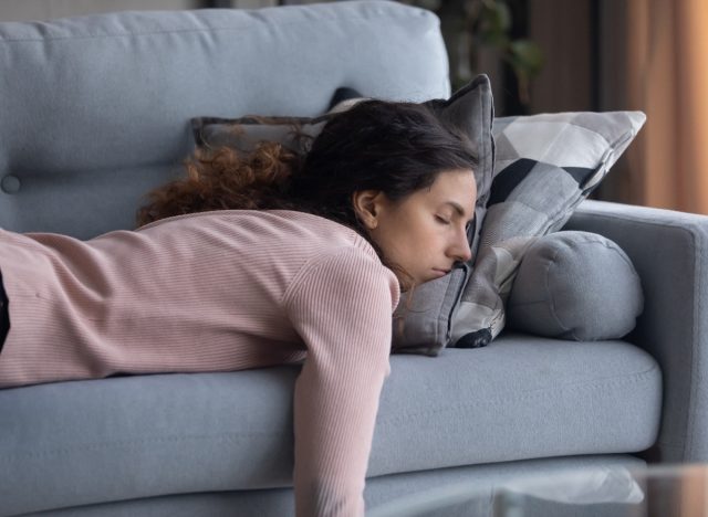 tired woman falling asleep on couch