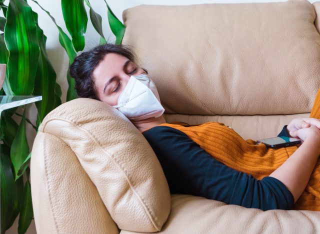 woman sleeping on couch in mask self-isolation