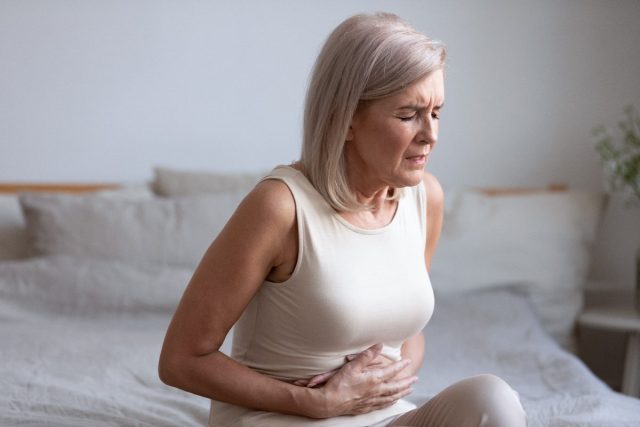 Mature woman with stomach pain due to fatty liver disease