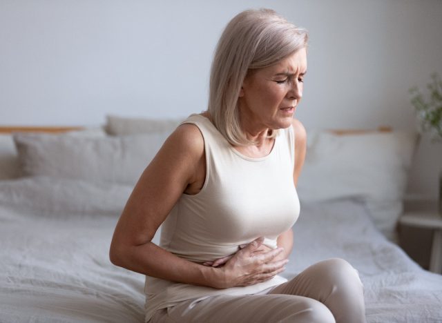 mature woman suffering from stomach pain caused by fatty liver disease