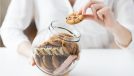woman taking cookie from cookie jar
