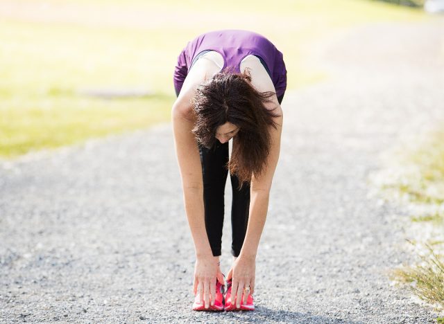 woman working out touching toes