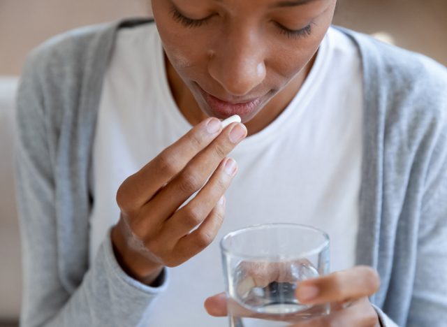 Eine Frau nimmt Antibiotika mit Wasser ein und verursacht eine Harnwegsinfektion