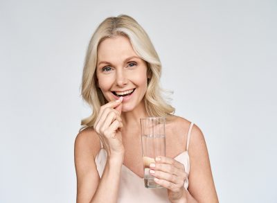 Woman taking supplement with water