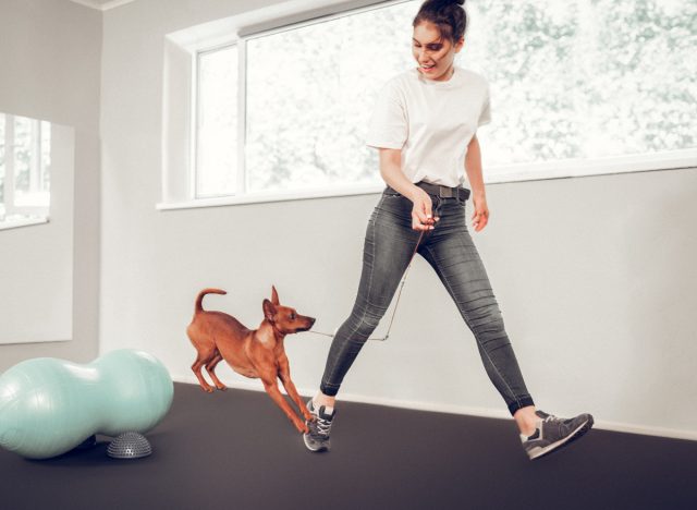 active woman training dog, exercises to do with your dog indoors