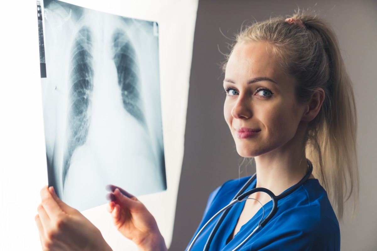 Caucasian,Blonde,Female,Radiologist,Holding,Chest,X ray,And,Looking,At