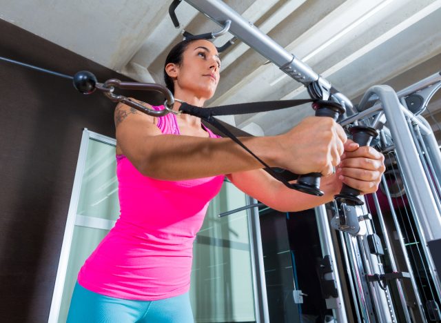 woman demonstrating cable fly breast-lifting exercises