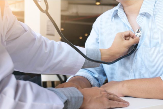 doctor checking heart with stethoscope