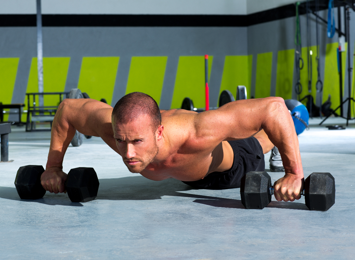 man performing dumbbell pushup as part of men's pot belly workout