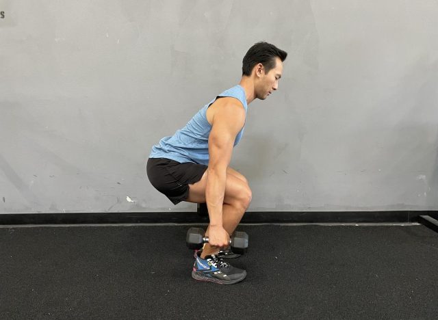 The trainer performs squats with dumbbells to reverse aging after 40