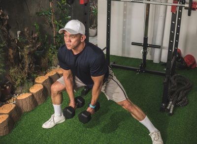 man performing dumbbell exercise to get rid of a flabby stomach