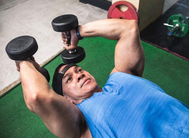 mand laver triceps-forlængelse med håndvægte for at slippe af med arm-jiggling