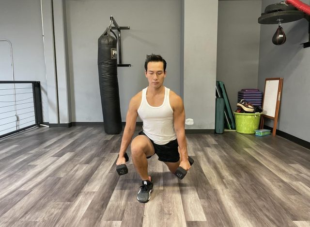 Pelatih melakukan dumbbell walking lunge