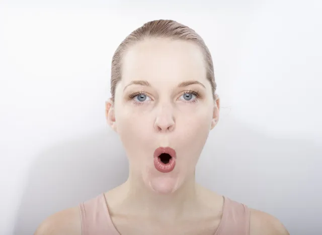 woman making "O" shape with mouth doing face jowl exercises