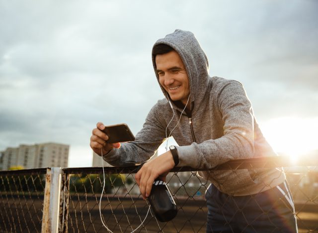 fit man streaming action movie on his phone after workout