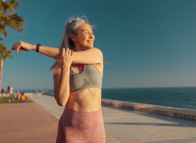 happy active woman stretching, keeping in shape after 40