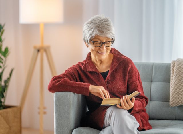 happy senior woman reading a book at home