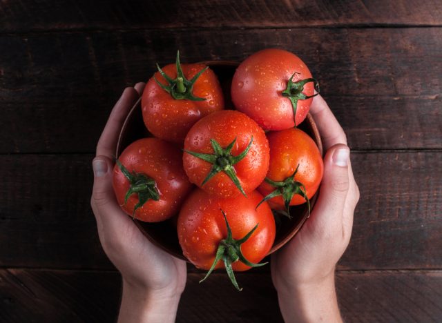holding bowl of fresh tomatoes