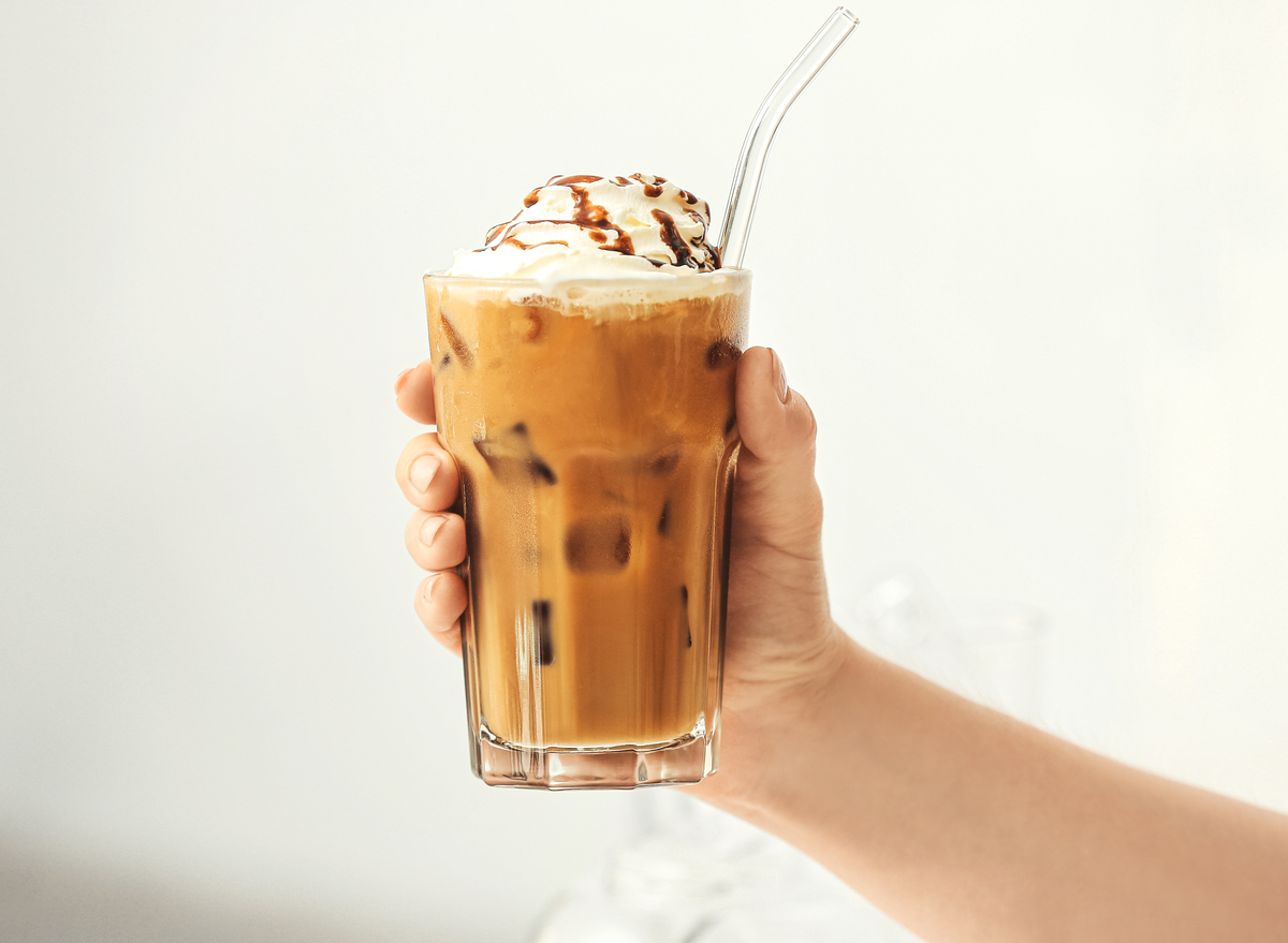 holding iced coffee with whipped cream