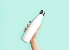 holding white reusable water bottle