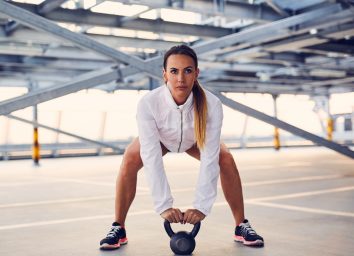 woman performing kettlebell swing to shrink visceral fat